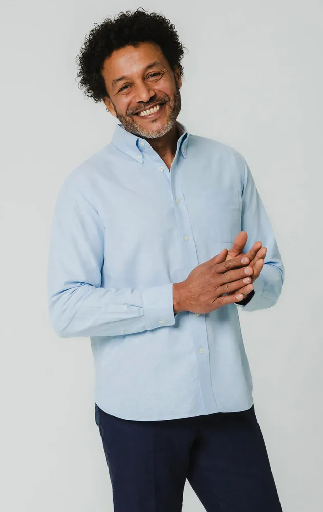 Model wearing a light blue Oxford shirt and navy trousers, ideal for men's smart casual office outfits.